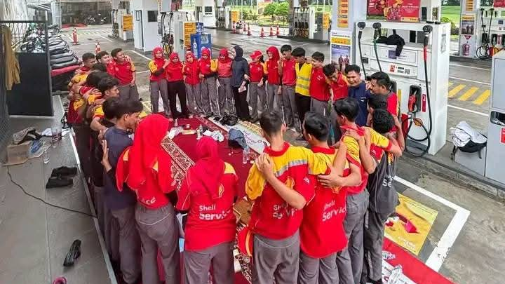 Karyawan berkumpul sebelum memulai hari kerja sat isu Shell hengkang.